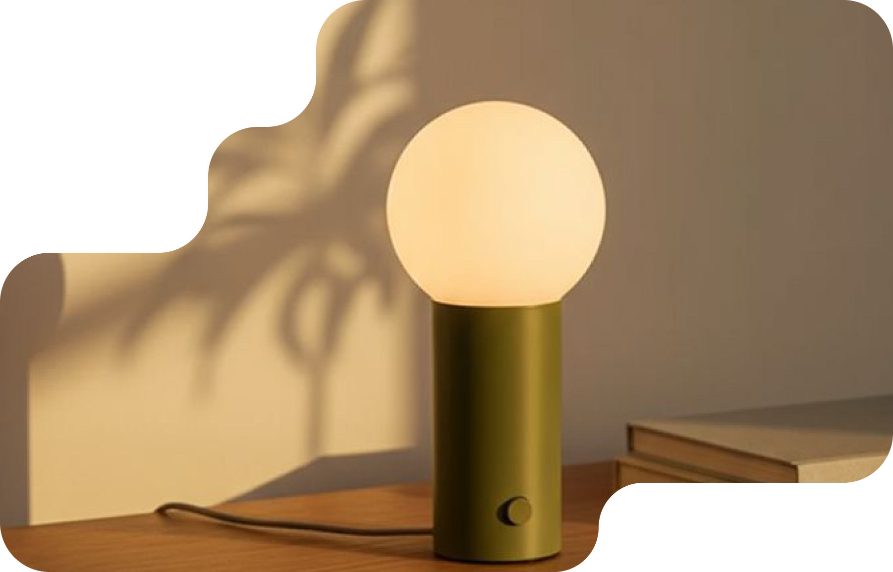 Olive table lamp with a glowing globe on a wooden desk